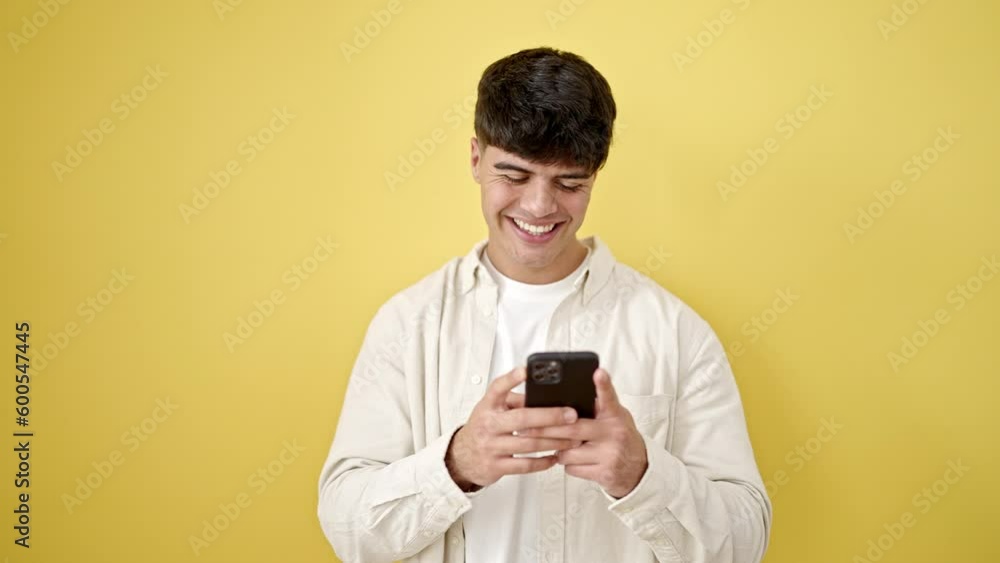 Young hispanic man using smartphone smiling over isolated yellow background Young hispanic man using smartphone smiling over isolated yellow background
