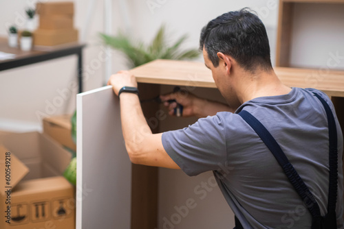 Canvas Print Furniture assembly in house of customer skilled man attaching white door to wood