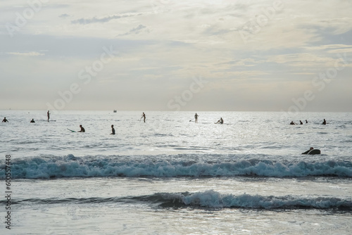 Silhouette Of surfer people on sunset beach catch oceans wave.Surfing sport and travel concept