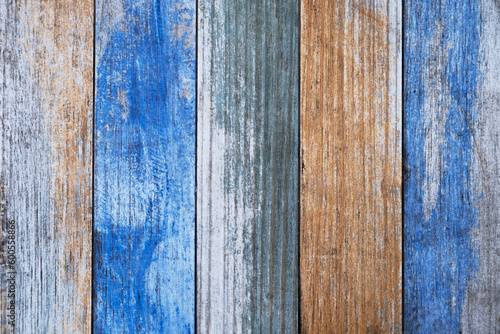 old wooden board with bright blue and beige paint and cracks. vertical lines. rough surface texture