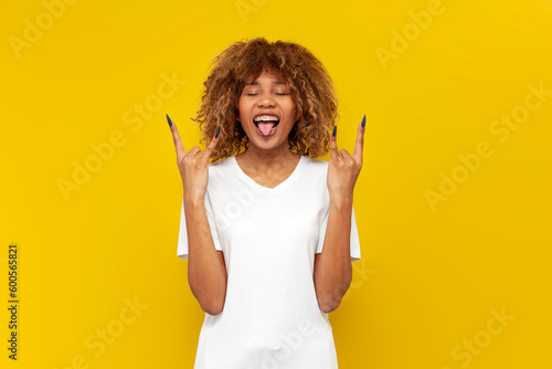 Wallpaper Mural crazy curly american girl in white t-shirt shows tongue and rock gesture with ha