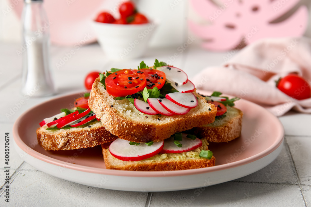 Plate with delicious radish bruschettas on white tiled table