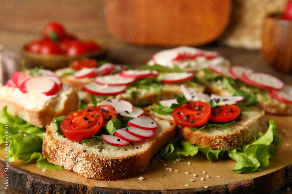 Board with delicious radish bruschettas on wooden table