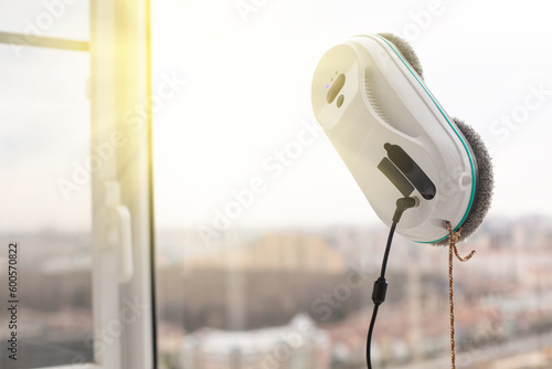 Smart vacuum cleaner washing windows. Home appliance concept