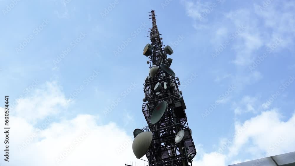 High industrial satellite tower against boundless blue sky High industrial satellite tower against boundless blue sky