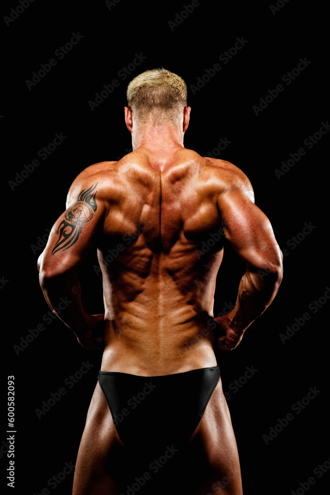 Bodybuilder Flexing Muscles against Black background 