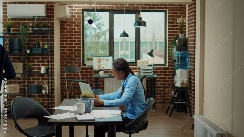 Startup employee writing data on laptop, planning executive briefing meeting to discuss new development vision. Female office worker examining corporate results in coworking space. Startup employee writing data on laptop, planning executive briefing meeting to discuss new development vision. Female office worker examining corporate results in coworking space.