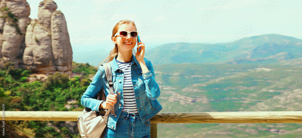 Travel concept, portrait happy smiling young woman calling on smartphone on hiking trail on top of the mountain Montserrat background