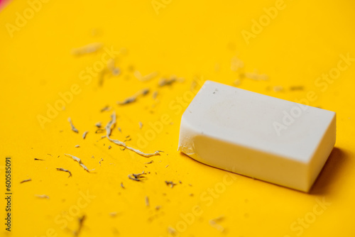Fotografía White eraser on a yellow background. Rubbish from erasure.