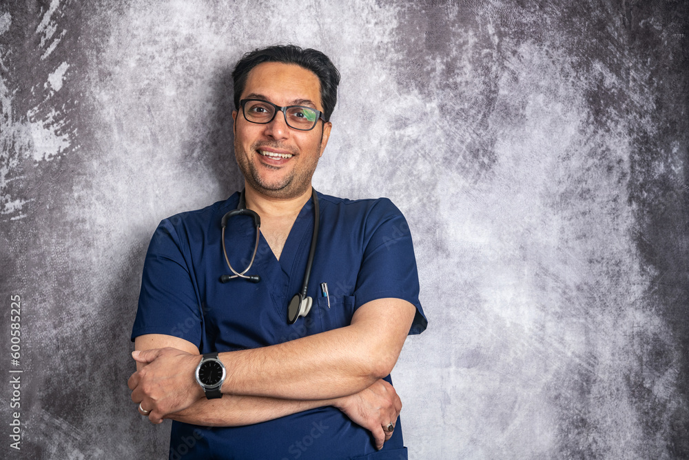 young smiling doctor in glasses with a stethoscope near a gray wall. Space for text. young smiling doctor in glasses with a stethoscope near a gray wall. Space for text.