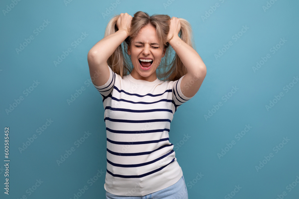 happy well-groomed european blond woman with healthy hair on a blue isolated background happy well-groomed european blond woman with healthy hair on a blue isolated background