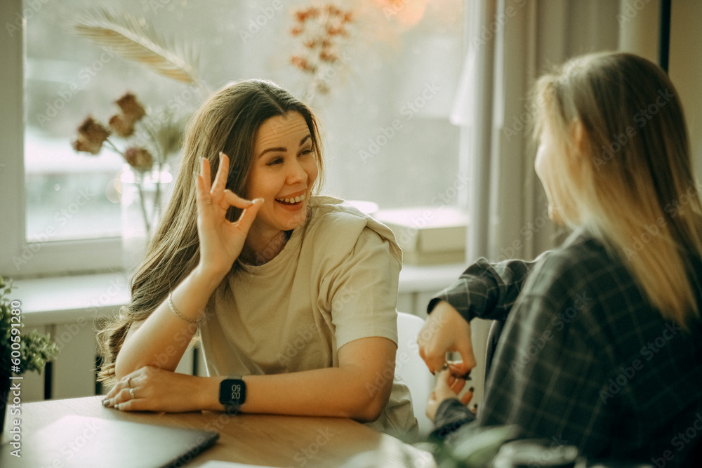 Friendly female colleagues having good relationships, pleasant conversation at workplace during coffee break Friendly female colleagues having good relationships, pleasant conversation at workplace during coffee break