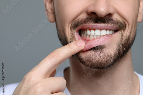 Man showing healthy gums on gray background  closeup. Space for text