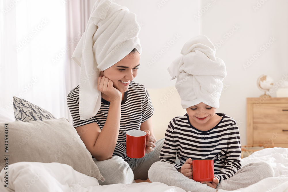Young mother and her daughter spending time together on bed at home Young mother and her daughter spending time together on bed at home