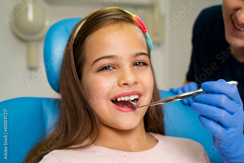 Little girl smiling while having dental check up , closeup shot, looking at camera 