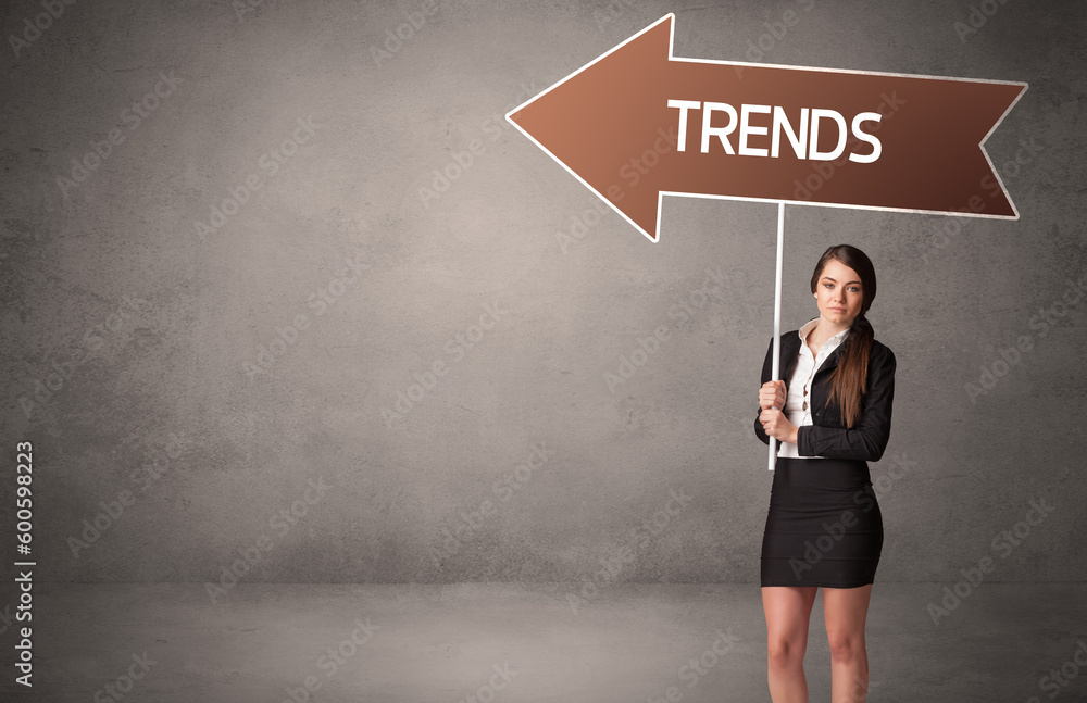 Young business person in casual holding road sign Young business person in casual holding road sign