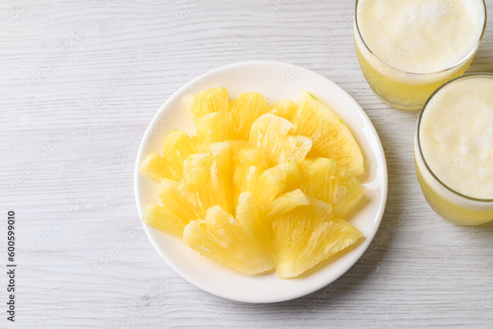 Sliced pineapple fruit with pineapple smoothie in glass, top view Sliced pineapple fruit with pineapple smoothie in glass, top view