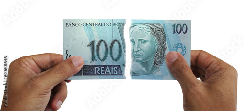 Torn money. Note of 100 reais. Currency of Brazil destroyed. Conceptual idea of ​​wasting money.