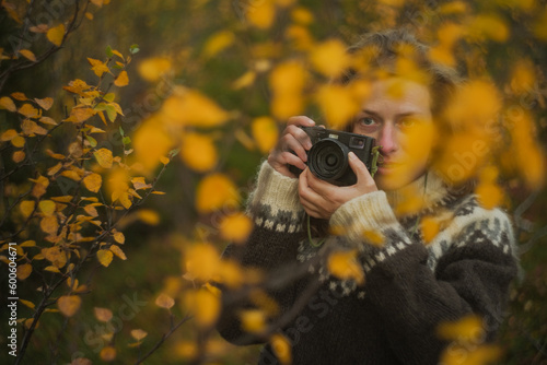 Caucasian female photographer using camera in yellow autumn forest