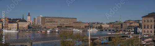 View over the bay Strömmen, old town Gamla Stan, Government buildings museums and the Opera house, pier with moored commuting boats, a sunny early tranquil summer day in Stockholm