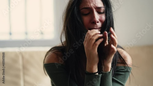 Distressed young woman overwhelmed with anxiety and sadness, feeling helpless and lost at home