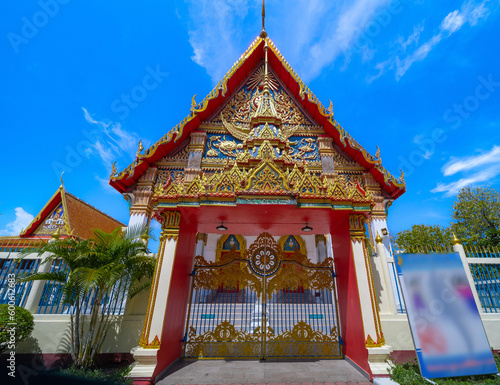 Beautiful Wat Buddhist temple in Phuket Karon Thailand. Decorated in beautiful ornate colours of Gold blue green red and White. Sunset Sunrise lovely sky and cloud colours