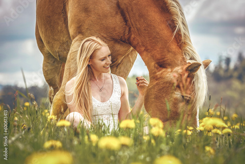 Horsemanship concept: Cute friendship scene between an equestrian woman and her haflinger horse in spring outdoors photo