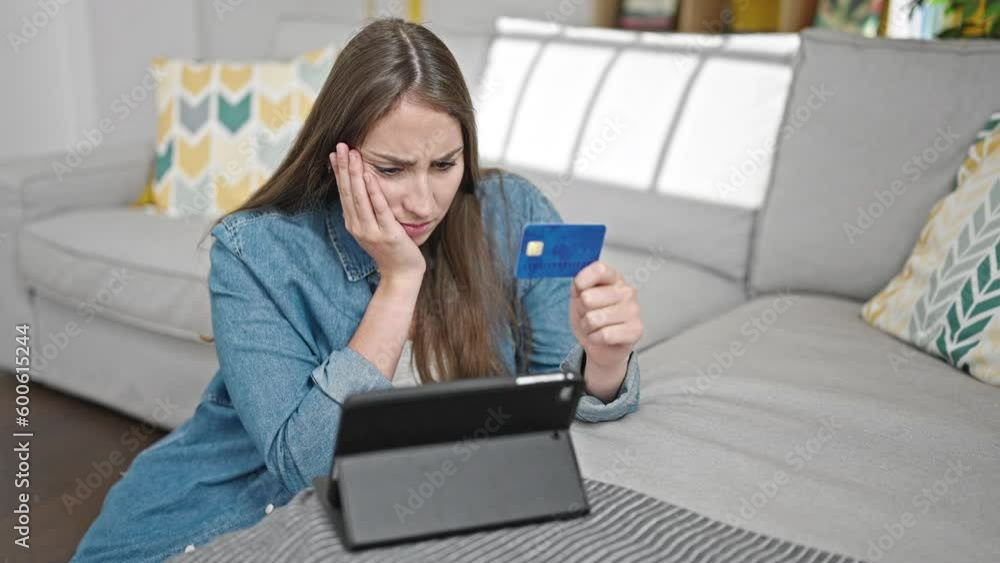 Young beautiful hispanic woman shopping with touchpad and credit card looking upset at home Young beautiful hispanic woman shopping with touchpad and credit card looking upset at home
