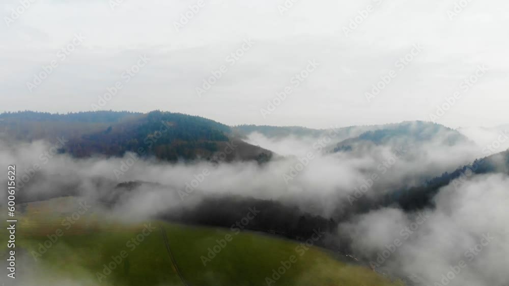 Drone view flying over the green field in the Baden-Württemberg, Odenwald Nature park on a foggy day, Germany Drone view flying over the green field in the Baden-Württemberg, Odenwald Nature park on a foggy day, Germany