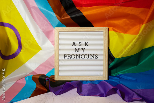 ASK MY PRONOUNS text Neo pronouns concept on Rainbow flag background gender pronouns. Non-binary people rights transgenders. Lgbtq community support assume my gender, respect pronouns tolerance equal photo