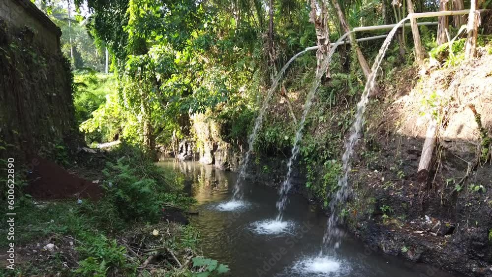 Bamboo Water Faucets Flowing in Balinese Forest River next to a Temple for Purification Ceremony in Ubud Bali Indonesia Bamboo Water Faucets Flowing in Balinese Forest River next to a Temple for Purification Ceremony in Ubud Bali Indonesia