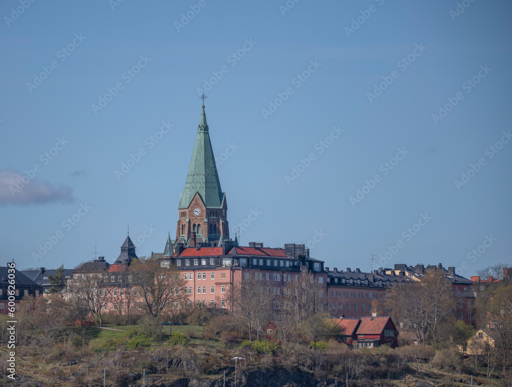 The tower of the church Katarina and old 1800s apartment houses on a hill in the district Södermalm, a sunny early tranquil summer day in Stockholm