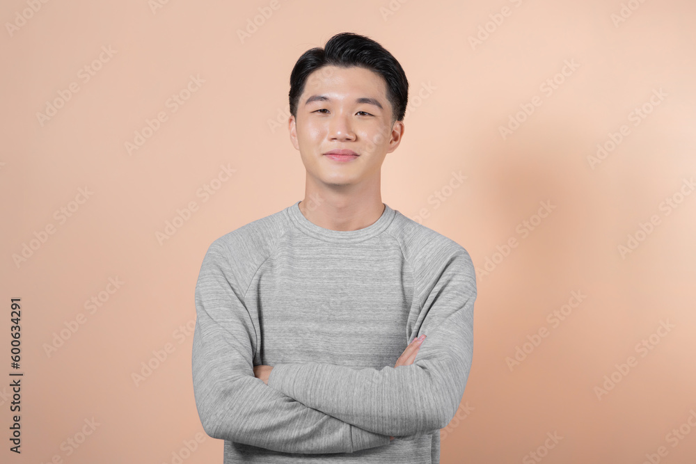 Young, handsome and friendly face man smile, dressed casually with happy and self-confident positive expression with crossed arms on beige background Young, handsome and friendly face man smile, dressed casually with happy and self-confident positive expression with crossed arms on beige background