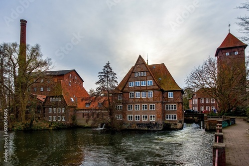 Ratsmuhle or old water mill and Wasserturm or water tower on Ilmenau river at morning in Luneburg. Germany