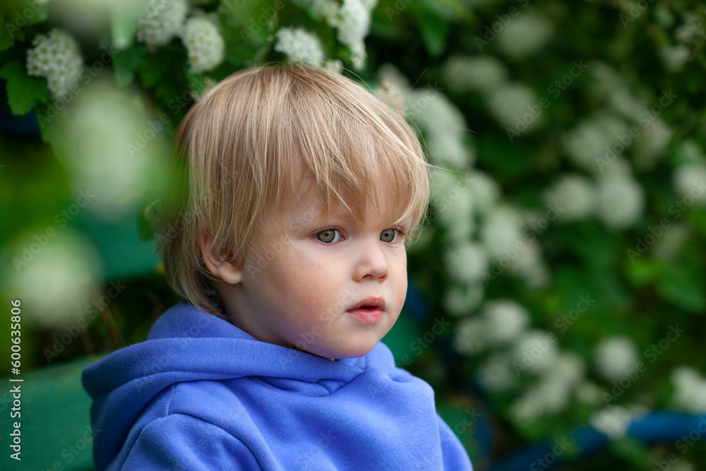 Small cute boy under flowering branch. The concept of allergies, sadness, loneliness. Small cute boy under flowering branch. The concept of allergies, sadness, loneliness.