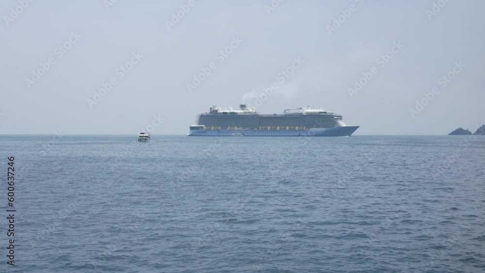 Giant cruise ship docked in the middle of ocean of Patong sea at Phuket under sunny day vacation holiday time. Luxuary Cruise ship tender in the sea in thailand Giant cruise ship docked in the middle of ocean of Patong sea at Phuket under sunny day vacation holiday time. Luxuary Cruise ship tender in the sea in thailand