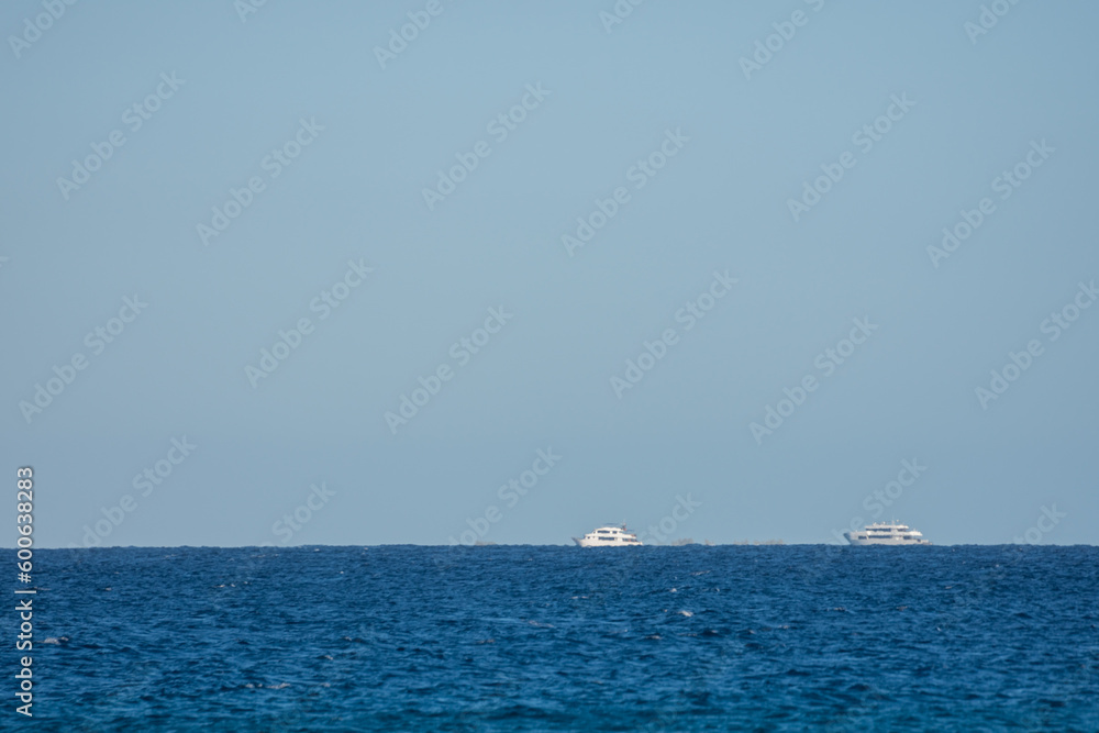 two white boats in blue water with blue sky in egypt