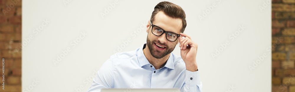 Mirthful man looking at the screen with contented smile Mirthful man looking at the screen with contented smile