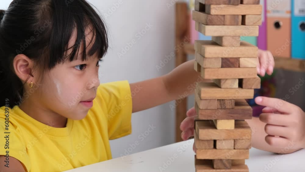 Cute Asian siblings having fun playing Jenga together. Two children ...