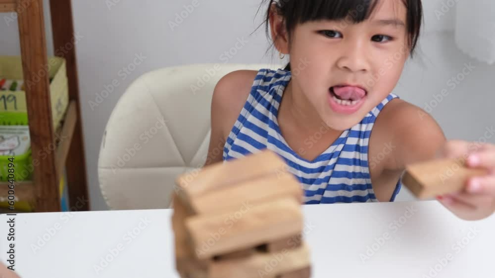 Cute Asian siblings having fun playing Jenga together. Two children ...