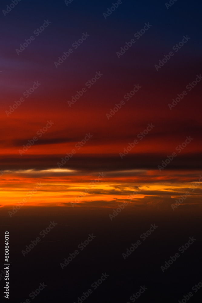 Fototapeta premium Dramatic sunset sky with orange red and blue shades. Aerial sunset landscape photo.