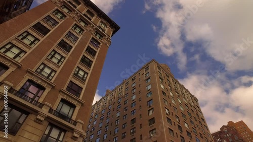 Low Angle Panning Shot Of Apartment Buildings By Bare Trees In City Against Sky - New York City, New York