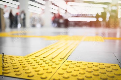 Tablou pe pânză Yellow tactile pavement for the blind on the floor in the mall.