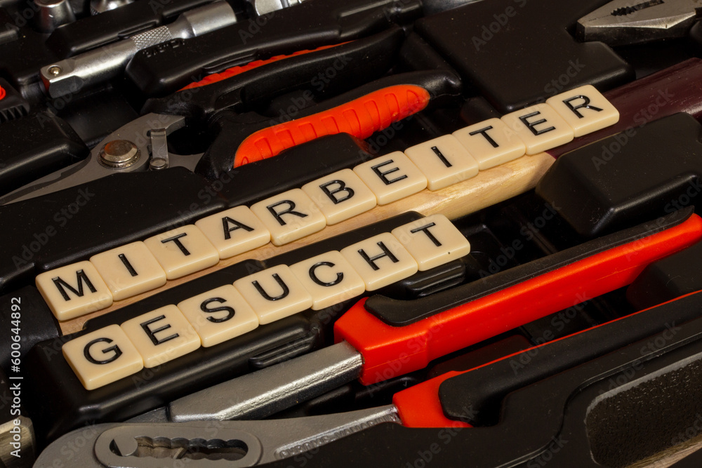 Fototapeta premium Symbolbild Mitarbeitersuche: In einem Werkzeugkoffer stehen mit Buchstabenwürfeln die Worte Mitarbeiter gesucht