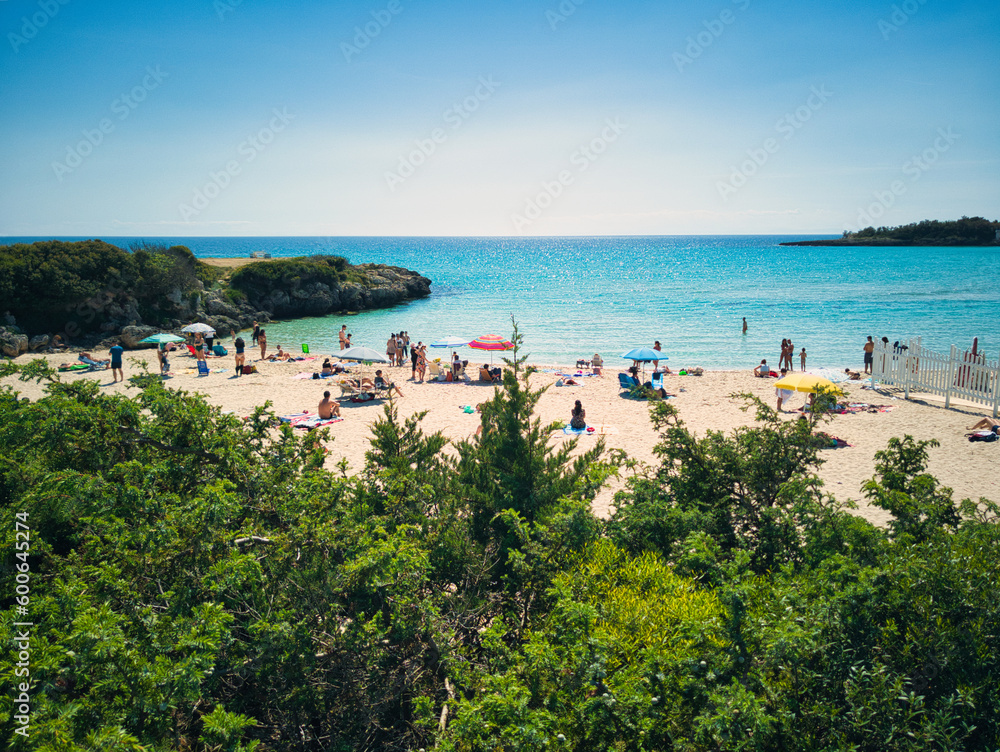 paesaggio estivo, calda giornata di sole sulla spiaggia, in riva al mare blu cristallino con gli ombrelloni. La stagione estiva è iniziata
