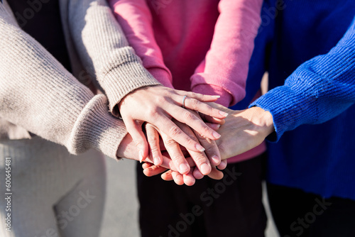 close-up of three friends' hands clasped, concept of friendship and bonding