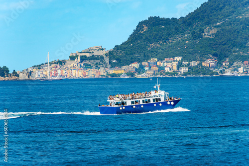 Tour boat or ferry with many tourists in motion in the Gulf of La Spezia to the Cinque Terre, Porto Venere or Portovenere town and Palmaria island, Liguria, Italy, Europe.