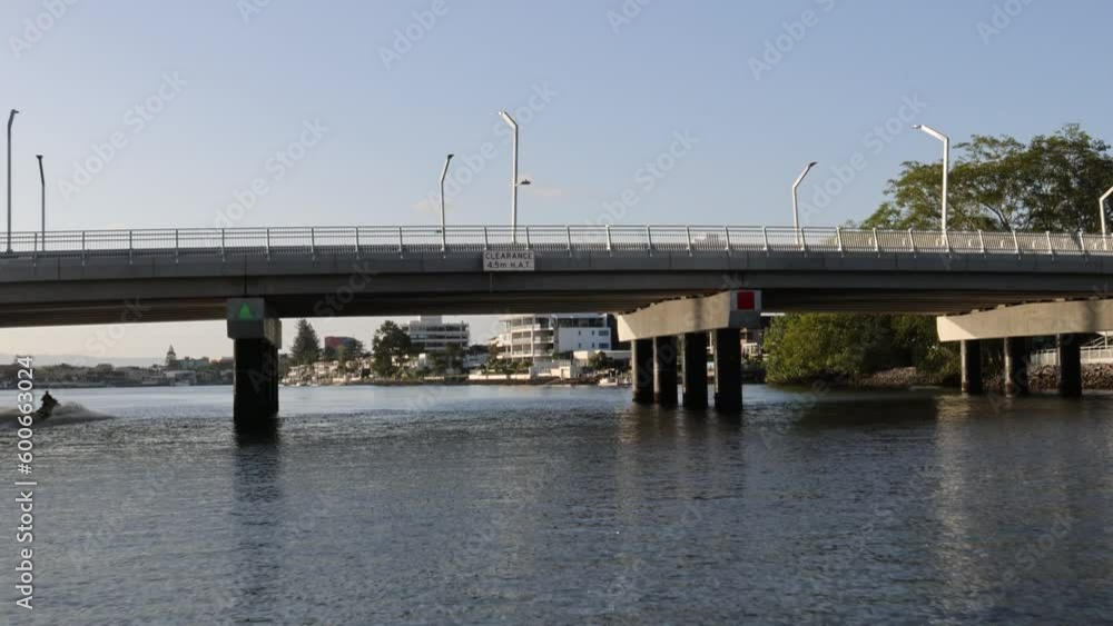 Gold Coast, Queensland, Australia - January 10, 2023. Cruising under a Bridge and along a Residential Canal Gold Coast, Queensland, Australia - January 10, 2023. Cruising under a Bridge and along a Residential Canal
