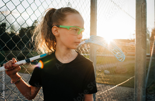 Girl holding a innebandy stick waiting to play a game at sunset photo