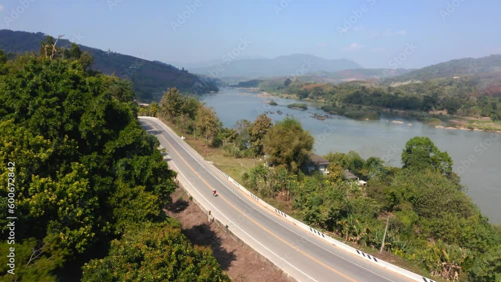 Motorcycle Driving On Rural Road Near Mekong River, Golden Triangle, East Asia Motorcycle Driving On Rural Road Near Mekong River, Golden Triangle, East Asia